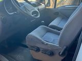 the interior of a white van with a black seat and steering wheel