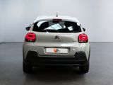 the rear of a silver car is parked in a white room