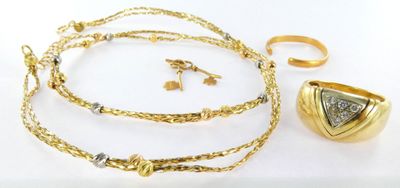 jewelry on a white surface including a gold necklace, ring, and bracelet