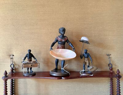 Plusieurs figurines sont posées sur une étagère sur laquelle se trouve un bol.