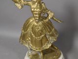 figurine en or représentant une femme vêtue d'un tutu et tenant un éventail