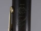 an image of a close up of a clarinet with a black body and gold hardware