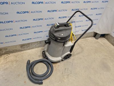 un aspirateur est posé par terre devant un mur