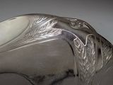 a close up of a silver plate with a bird on it