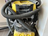 a yellow and black vacuum on the floor next to a wall