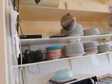 beaucoup d'assiettes et de casseroles sur les étagères de la cuisine