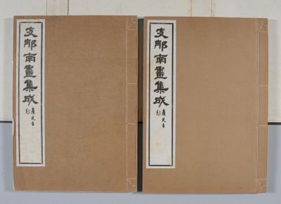 deux livres portant des inscriptions en caractères asiatiques, posés sur une table