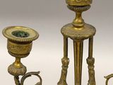 an antique brass candelabra with a marble base and two candles