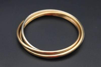 gros plan d'une bague en or sur une surface noire
