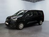 La camionnette noire est garée dans une grande pièce aux murs blancs.