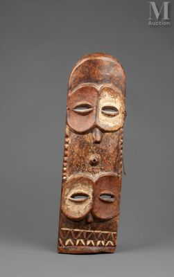 a wooden mask with three faces on it