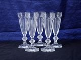 a set of four clear glass wine glasses sitting on top of a table