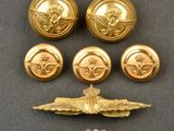 three gold buttons and two silver buttons on a black surface