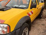 a yellow pick up truck parked next to other trucks