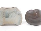 deux vases posés l'un à côté de l'autre sur une surface blanche