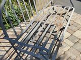 a metal bench that is sitting on the side of the road
