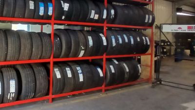 de nombreux pneus sur les étagères du garage