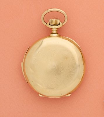 une montre de poche en or posée sur un fond rose, à côté d'une fleur blanche