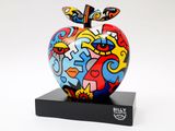 brightly colored apple sculpture on black stand on white background