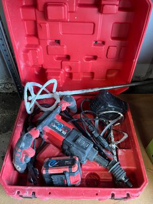 une boîte à outils rouge ouverte, contenant des outils, posée sur une table