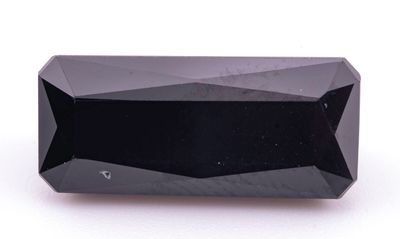 un gros plan d'un diamant noir sur une surface blanche