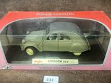 une vieille maquette de voiture dans une boîte rose posée sur une surface marron