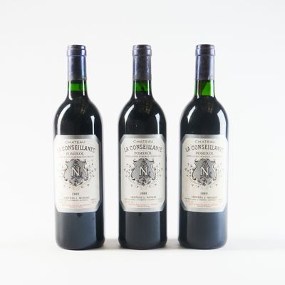 trois bouteilles de vin sont alignées sur une surface blanche