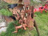 a tractor plow that is sitting in the grass