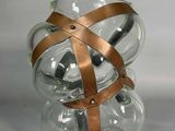 un vase en verre entouré d'une lanière en cuir