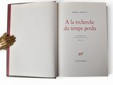 a book with a gold hand holding a red book