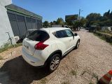 a white car parked in a gravel lot next to a building