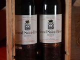 two bottles of wine sitting in a wooden box
