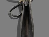 a black leather purse hanging on a hook on a gray wall