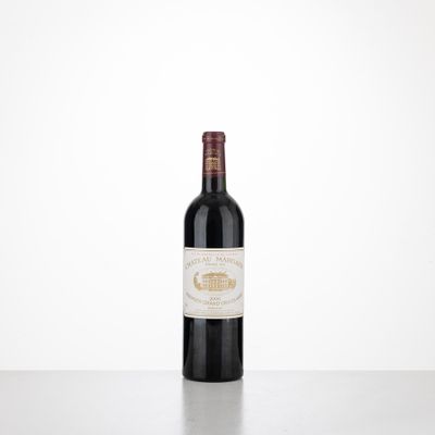 une bouteille de vin posée sur une table à côté d'un mur blanc