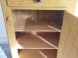 a wooden cabinet with a door open on the floor