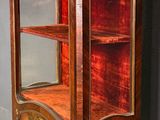 a wooden cabinet with a glass door in the corner
