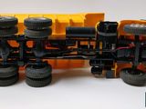 a yellow toy truck with four tires on it