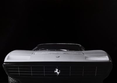photographie en noir et blanc d'une voiture de sport classique dans l'obscurité