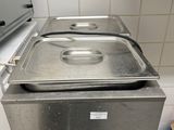 une casserole en métal posée sur une cuisinière dans une cuisine