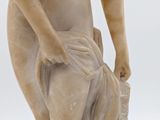 marble statue of a woman holding a book in her right hand
