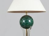 une lampe verte avec un abat-jour blanc posée sur une table en bois