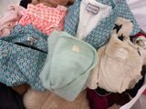 a basket full of clothes and a teddy bear in it