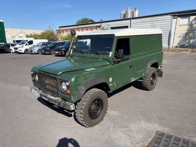 a green land rover parked in a parking lot