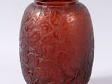 a red vase that is sitting on a white surface