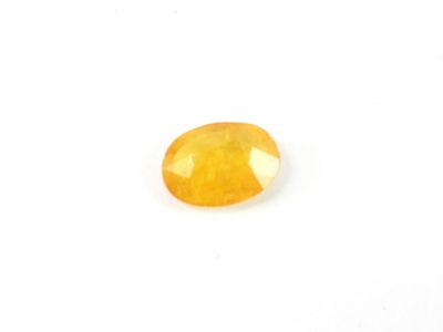 a yellow sapphire stone on a white background