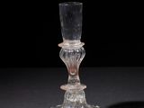 a glass candle holder that is sitting on a table