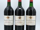 three bottles of red wine sitting next to each other on a white surface