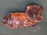 a brown animal shaped object on a green surface