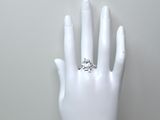 une main portant une bague, posée sur un mannequin