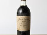 une vieille bouteille de vin posée sur une table en bois
